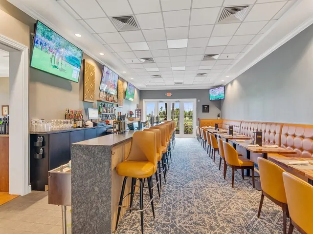 a dining hall with stainless steel appliances granite countertop a stove a sink a dining table and chairs with the view of kitchen