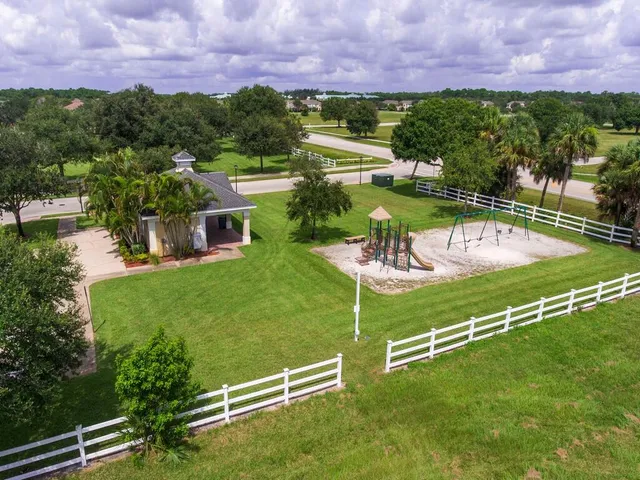 a view of a swimming pool with a yard and a fence