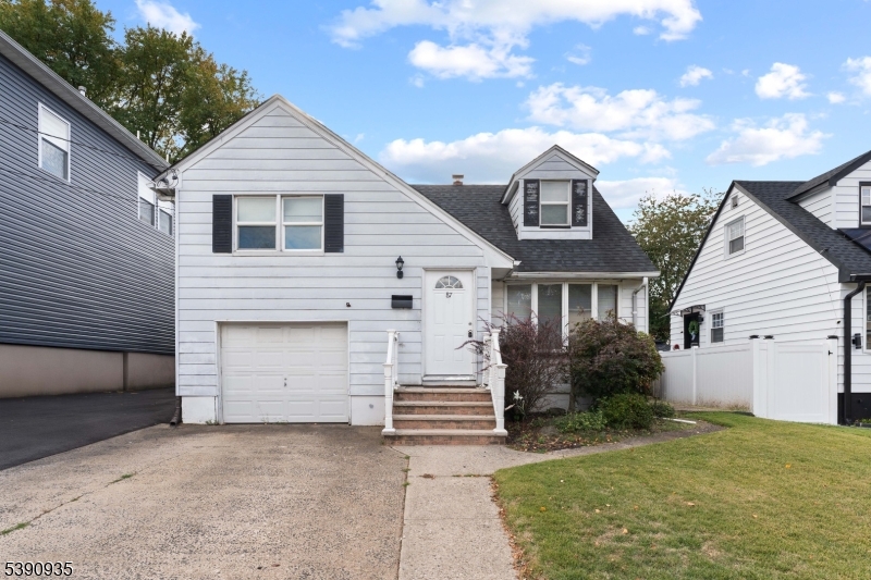 87 Pompton Avenue Little Falls, NJ 07424 - Photo 1 of 34 a front view of a house with a yard and garage