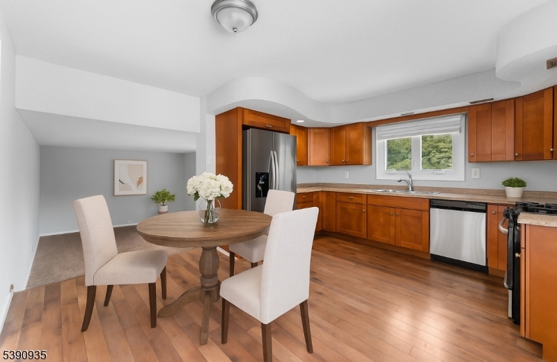 87 Pompton Avenue Little Falls, NJ 07424 - Photo 12 of 34 a kitchen with a table chairs a sink dishwasher window and cabinets