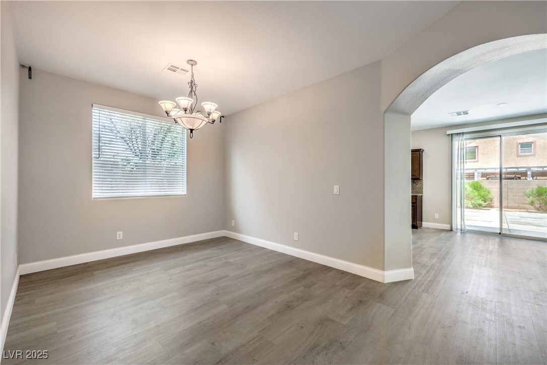 585 Foster Springs Road Las Vegas, NV 89148 - Photo 8 of 39 Unfurnished room with arched walkways, a chandelier, and wood finished floors