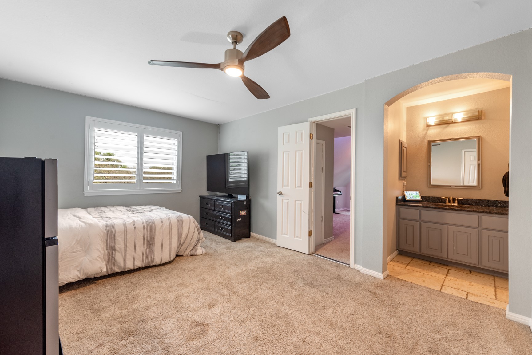664 Ranchers Club Lane, Unit 1 Driftwood, TX 78619 - Photo 23 of 40 a large bedroom with a bed and a flat screen tv