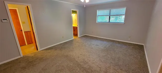 a view of a house with a small yard and large tree