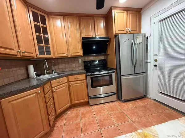 a kitchen with granite countertop a refrigerator and a sink