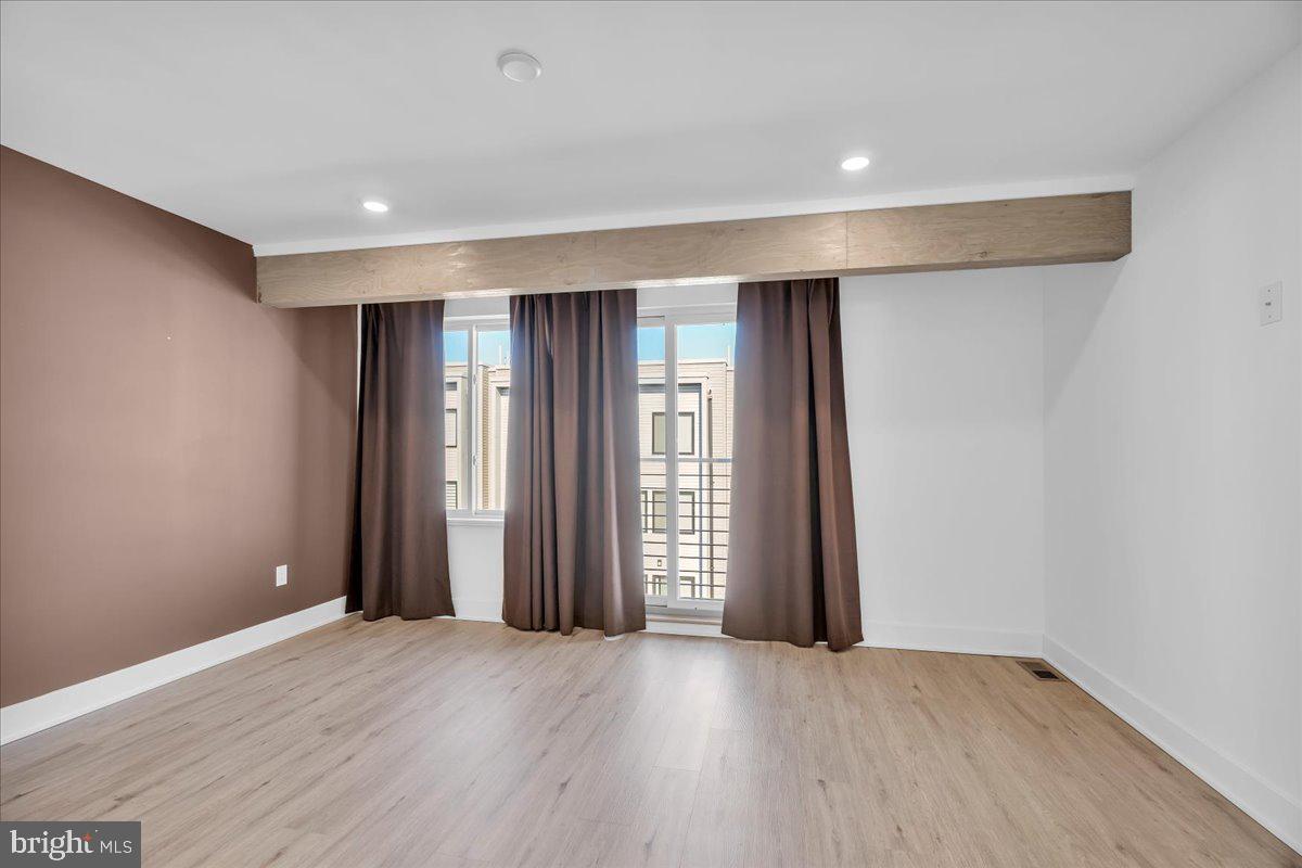 2615 East Boston Street, Unit 2 Philadelphia, PA 19125 - Photo 13 of 24 an empty room with wooden floor and windows