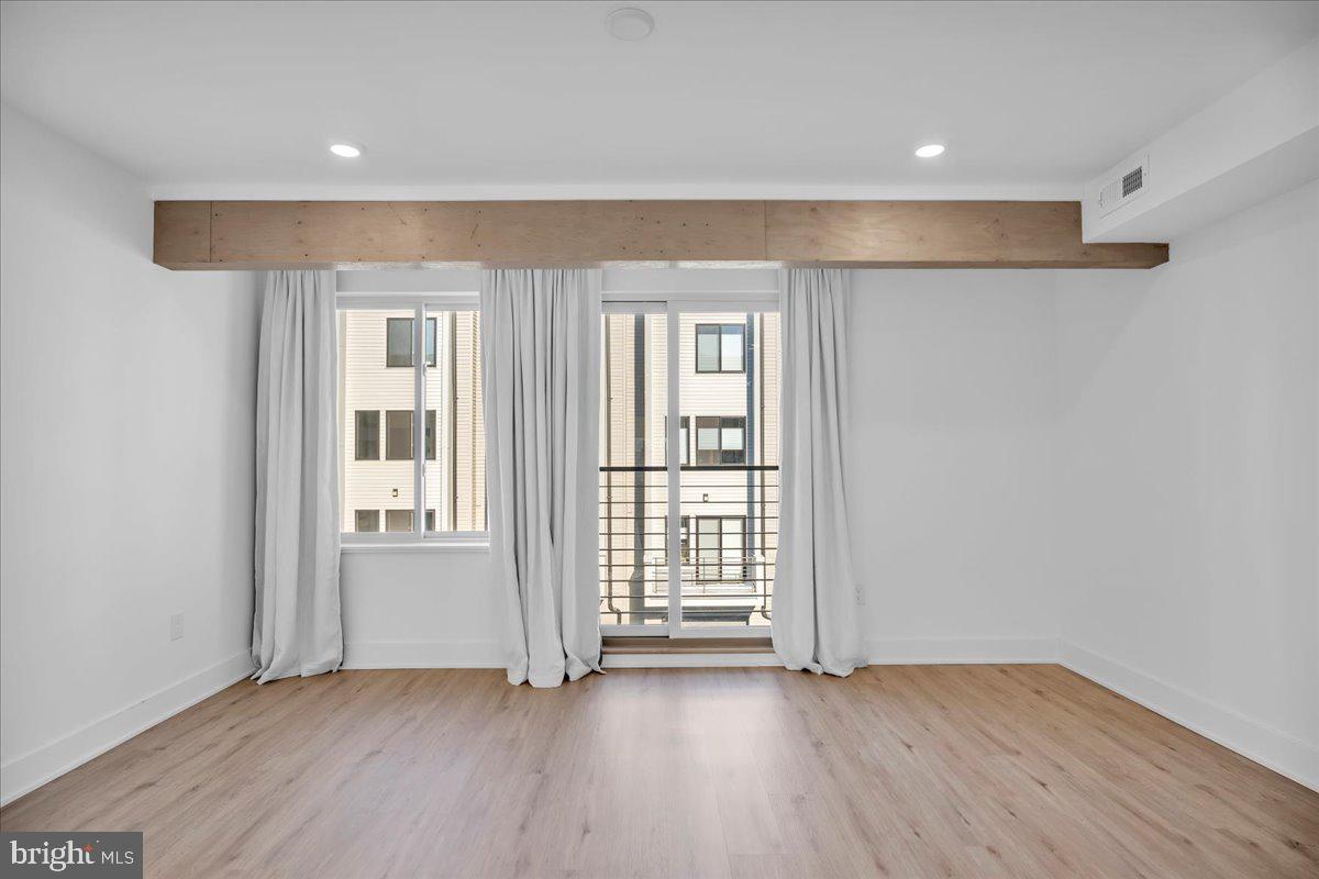2615 East Boston Street, Unit 2 Philadelphia, PA 19125 - Photo 10 of 24 an empty room with wooden floor and windows
