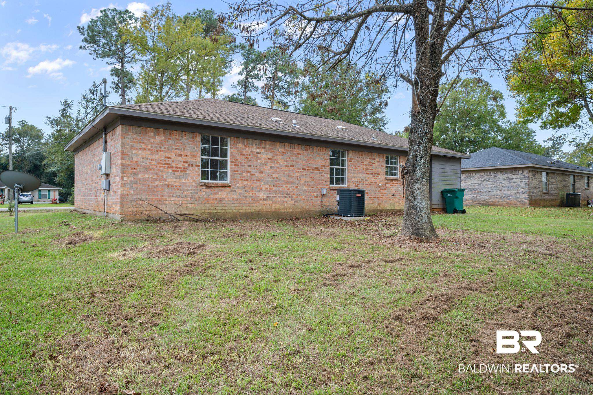 811 East Verbena Avenue Foley, AL 36535 - Photo 6 of 16 Back of property with central AC unit and a yard