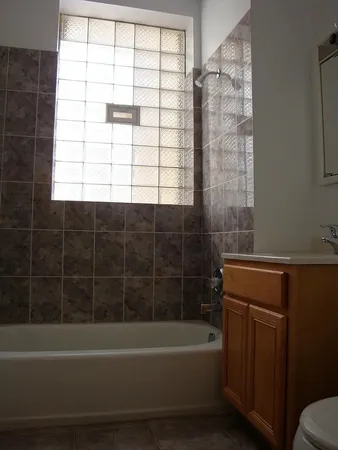 a bathroom with a bathtub a window and a shower