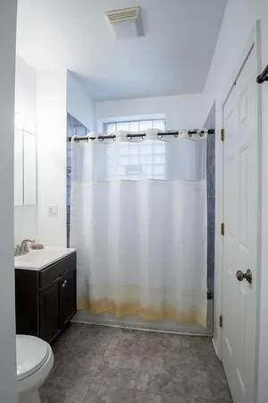 a bathroom with a sink a toilet a mirror and shower