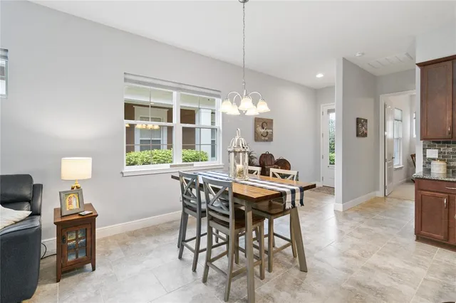 a kitchen with stainless steel appliances a sink a stove a refrigerator cabinets and chairs