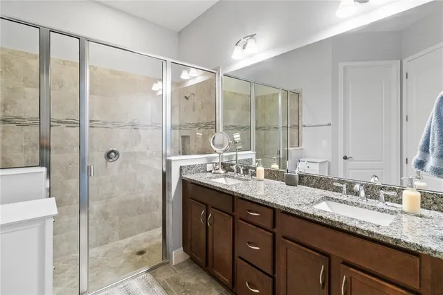 a bathroom with a granite countertop tub sink toilet and mirror