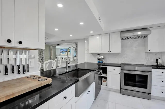 a kitchen with stainless steel appliances granite countertop a refrigerator and a window