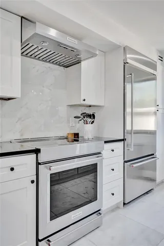 a kitchen with stainless steel appliances granite countertop a sink a stove and cabinets