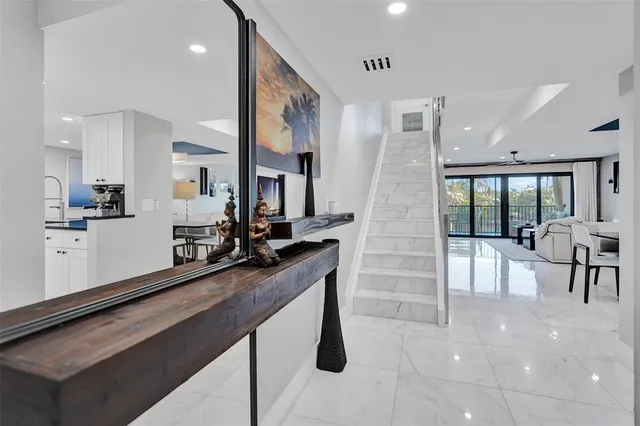 a kitchen with stainless steel appliances granite countertop a stove white cabinets a sink and a refrigerator