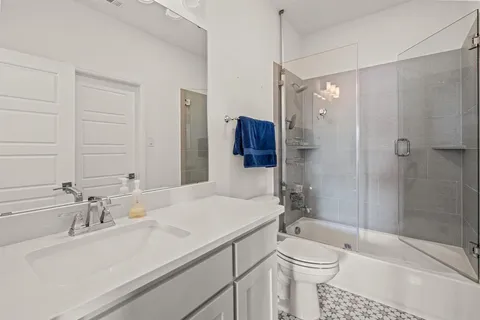 a bathroom with a sink toilet vanity and shower