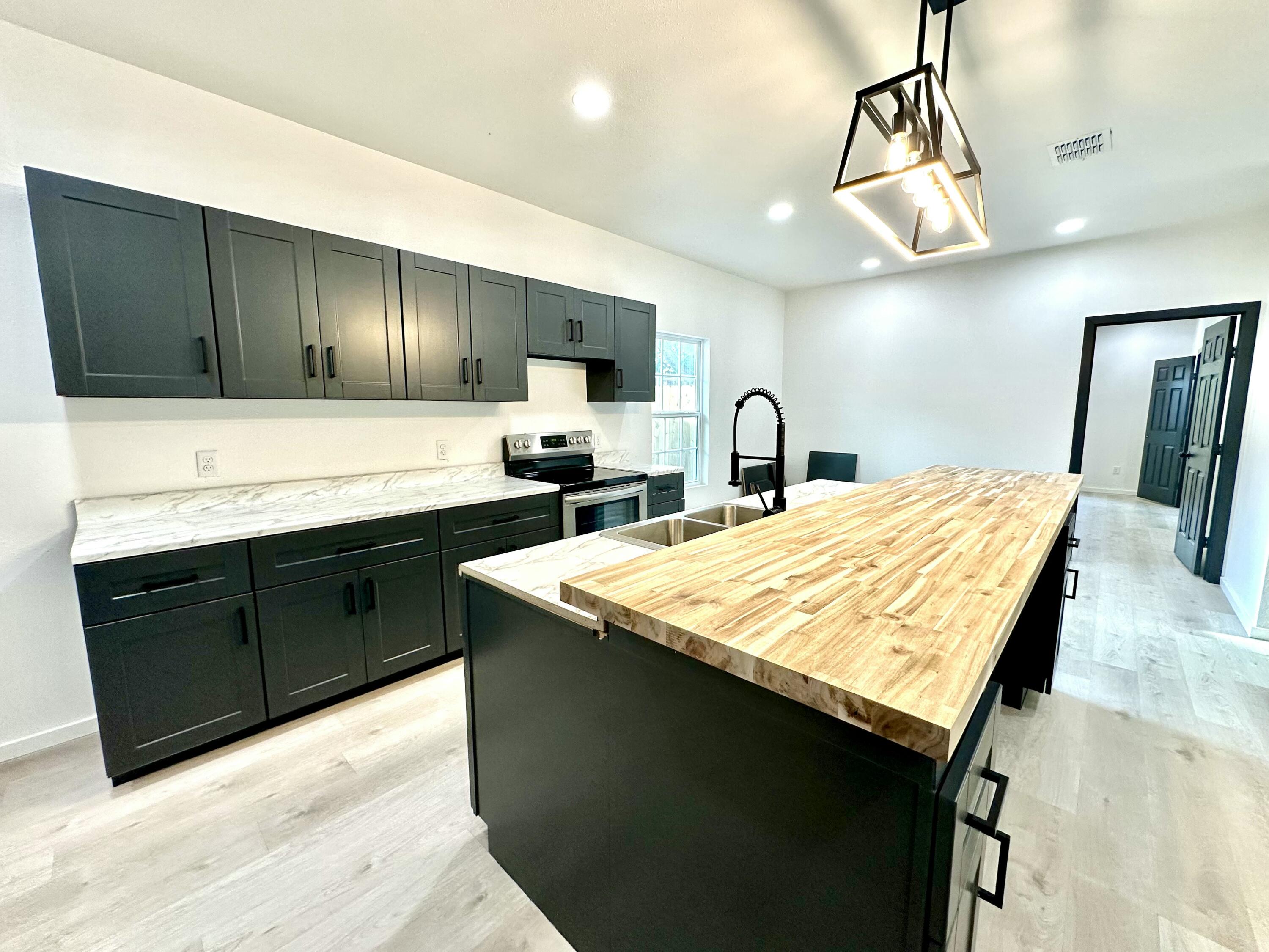 2617 47th Street Lubbock, TX 79413 - Photo 4 of 12 a kitchen with a stove a sink and a refrigerator