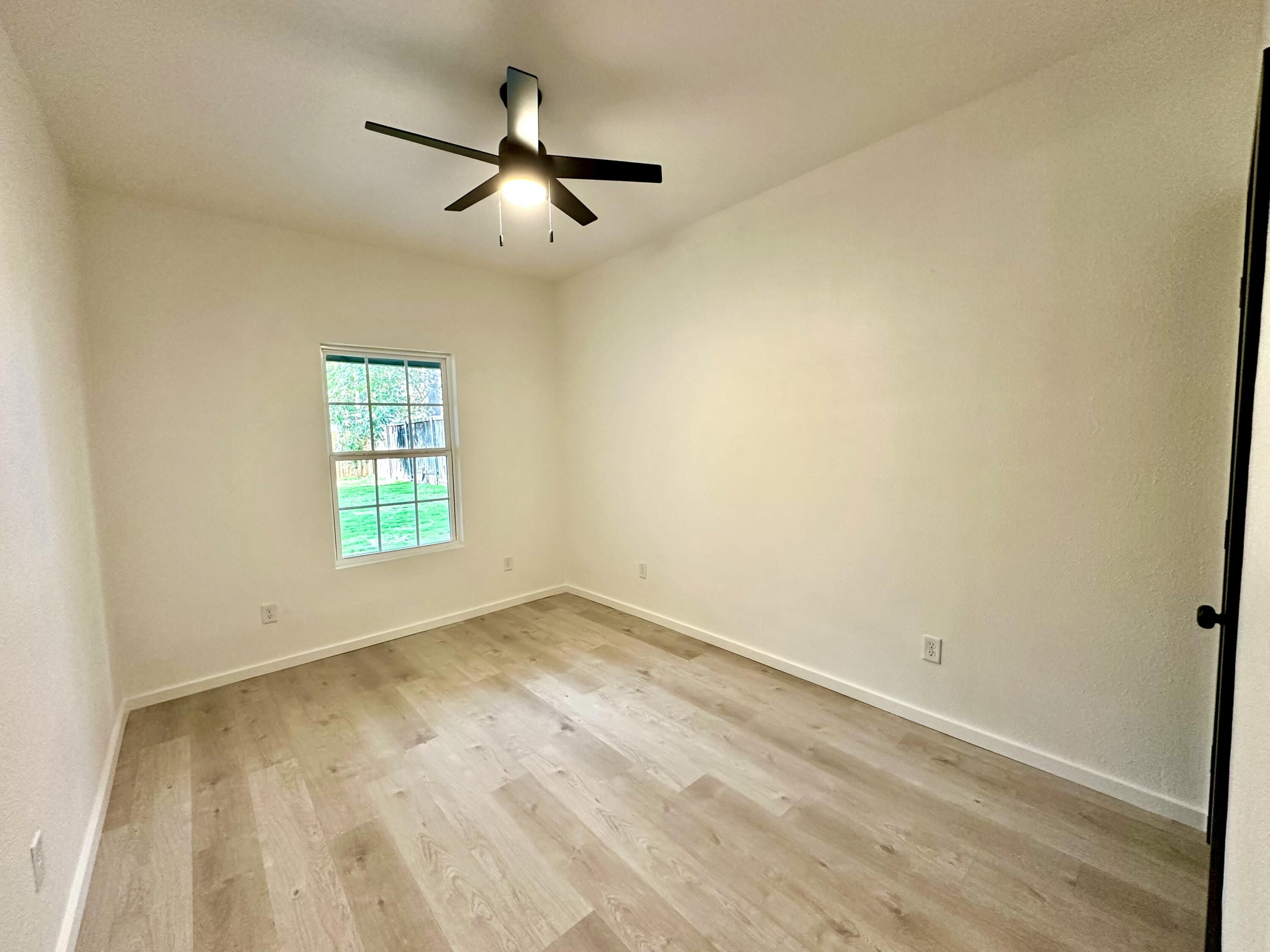 2617 47th Street Lubbock, TX 79413 - Photo 9 of 12 an empty room with a window and a fan