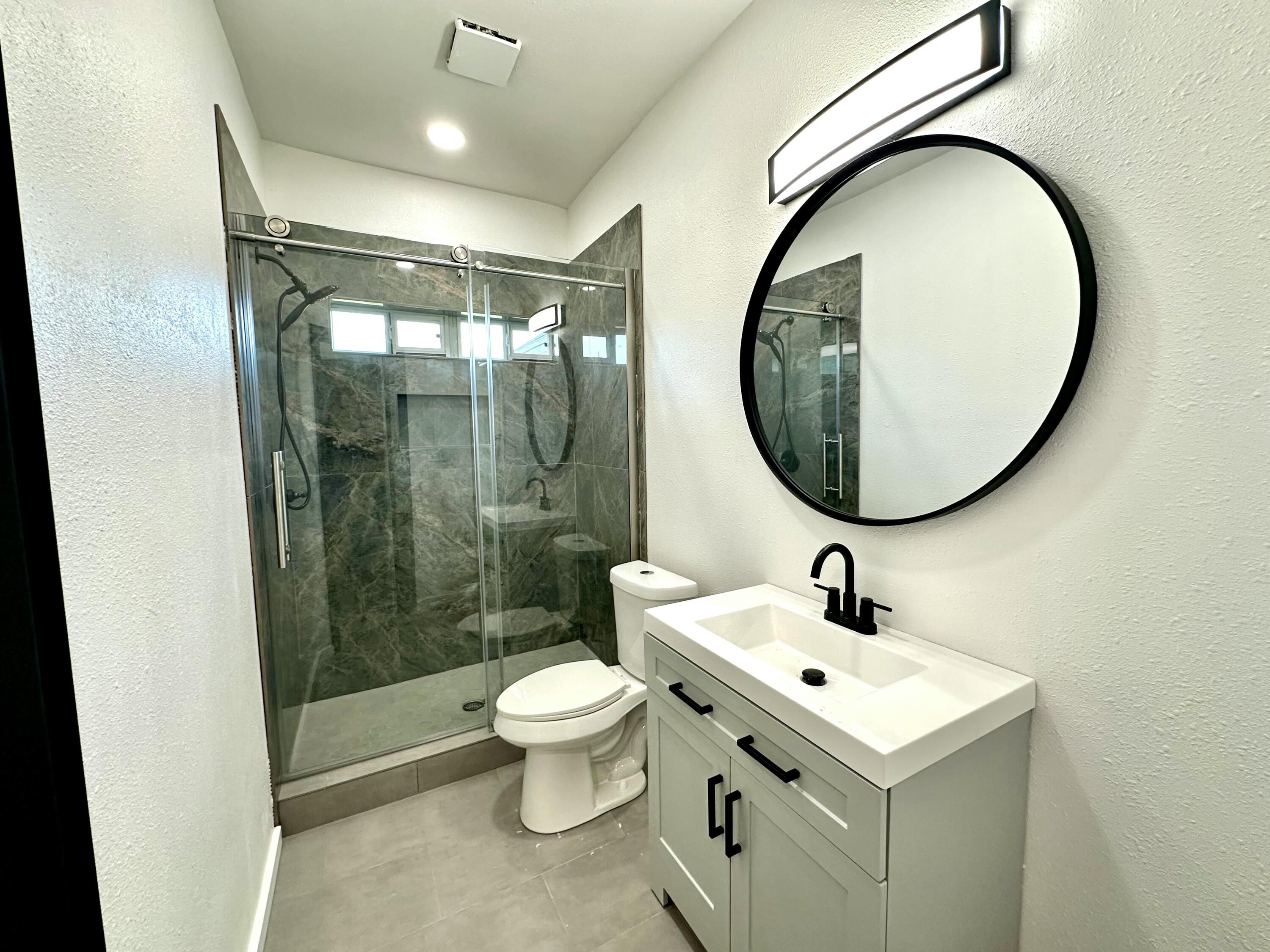 2617 47th Street Lubbock, TX 79413 - Photo 10 of 12 a bathroom with a sink a toilet and a mirror