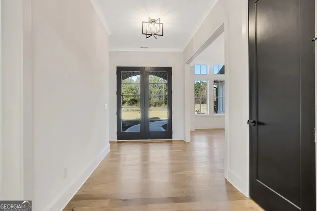 a view of a hallway with wooden floor and staircase