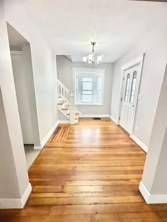 a room with wooden floor and chandelier