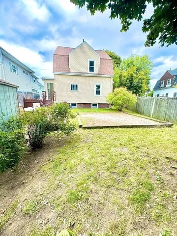 a view of a house with backyard and sitting area