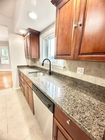 a kitchen with stainless steel appliances granite countertop a refrigerator a sink a stove and a window