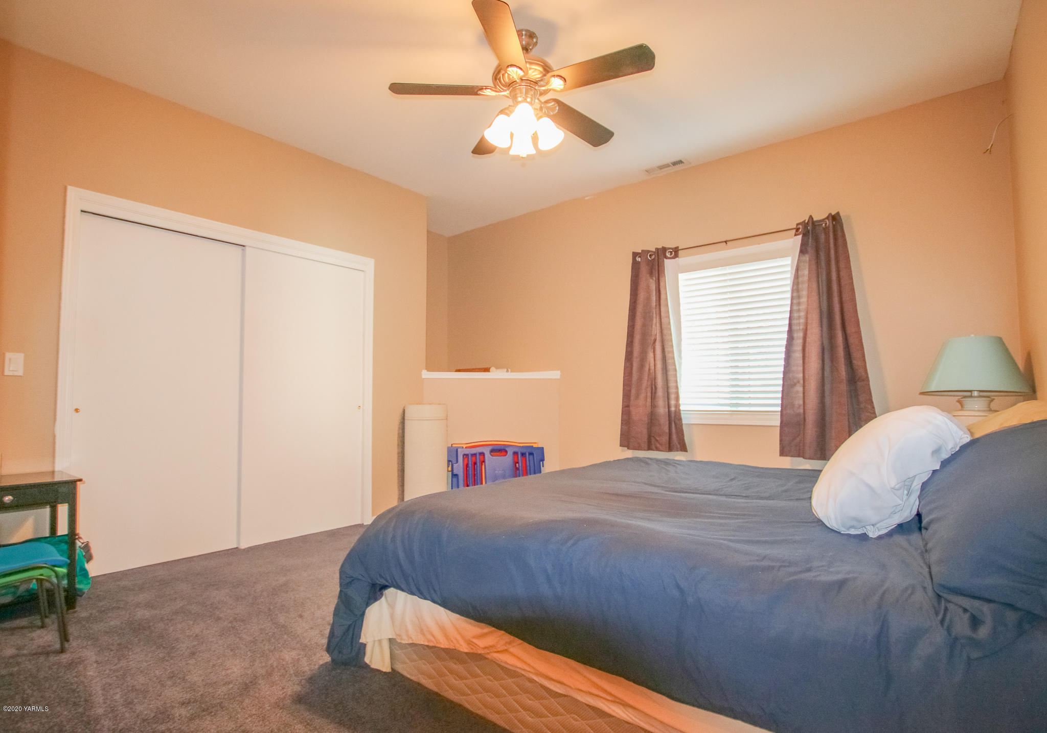 6608 Postma Road Yakima, WA 98901 - Photo 17 of 34 a bedroom with a large bed and a chandelier