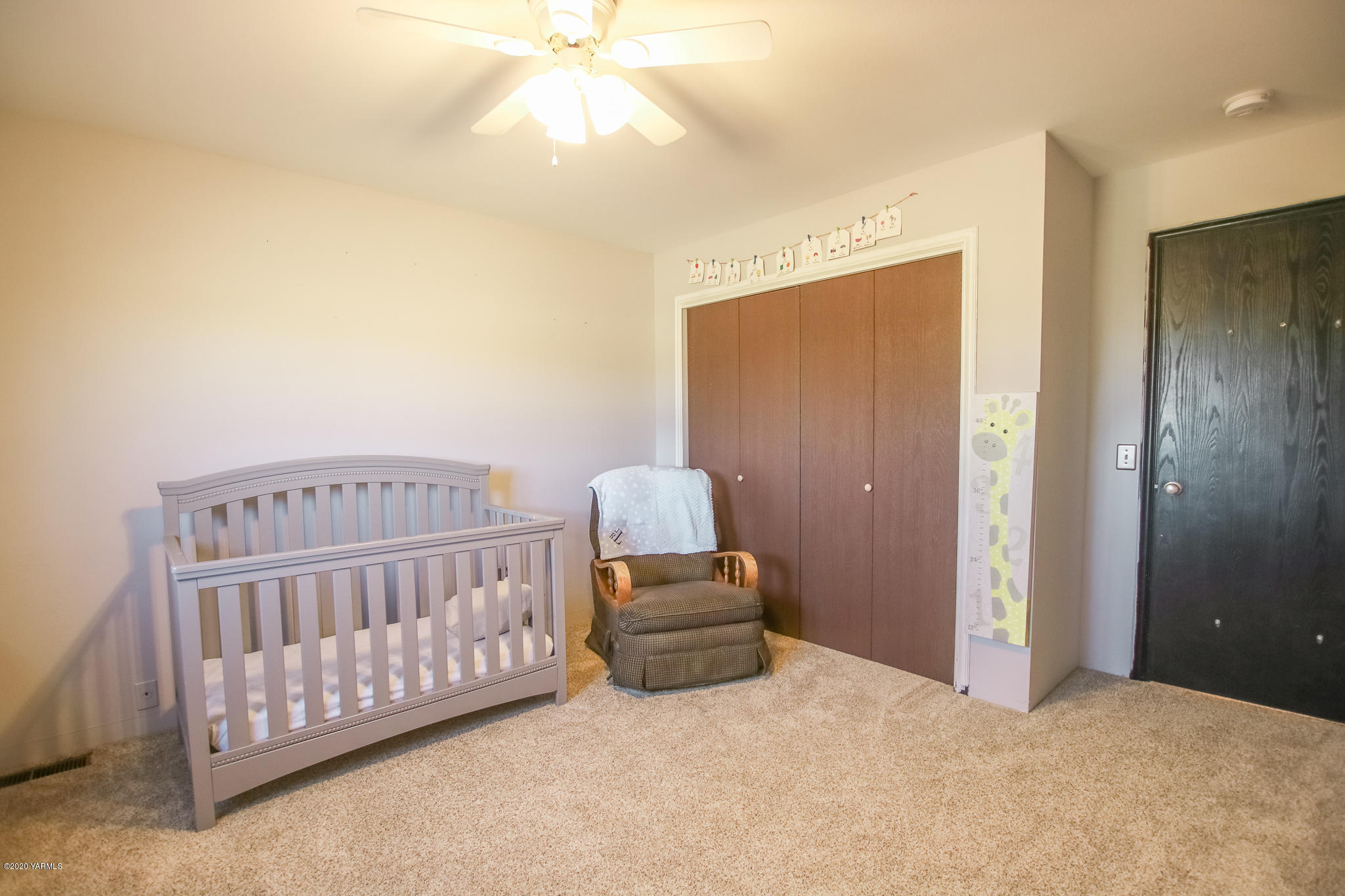 6608 Postma Road Yakima, WA 98901 - Photo 24 of 34 a bedroom with a bed and a chandelier