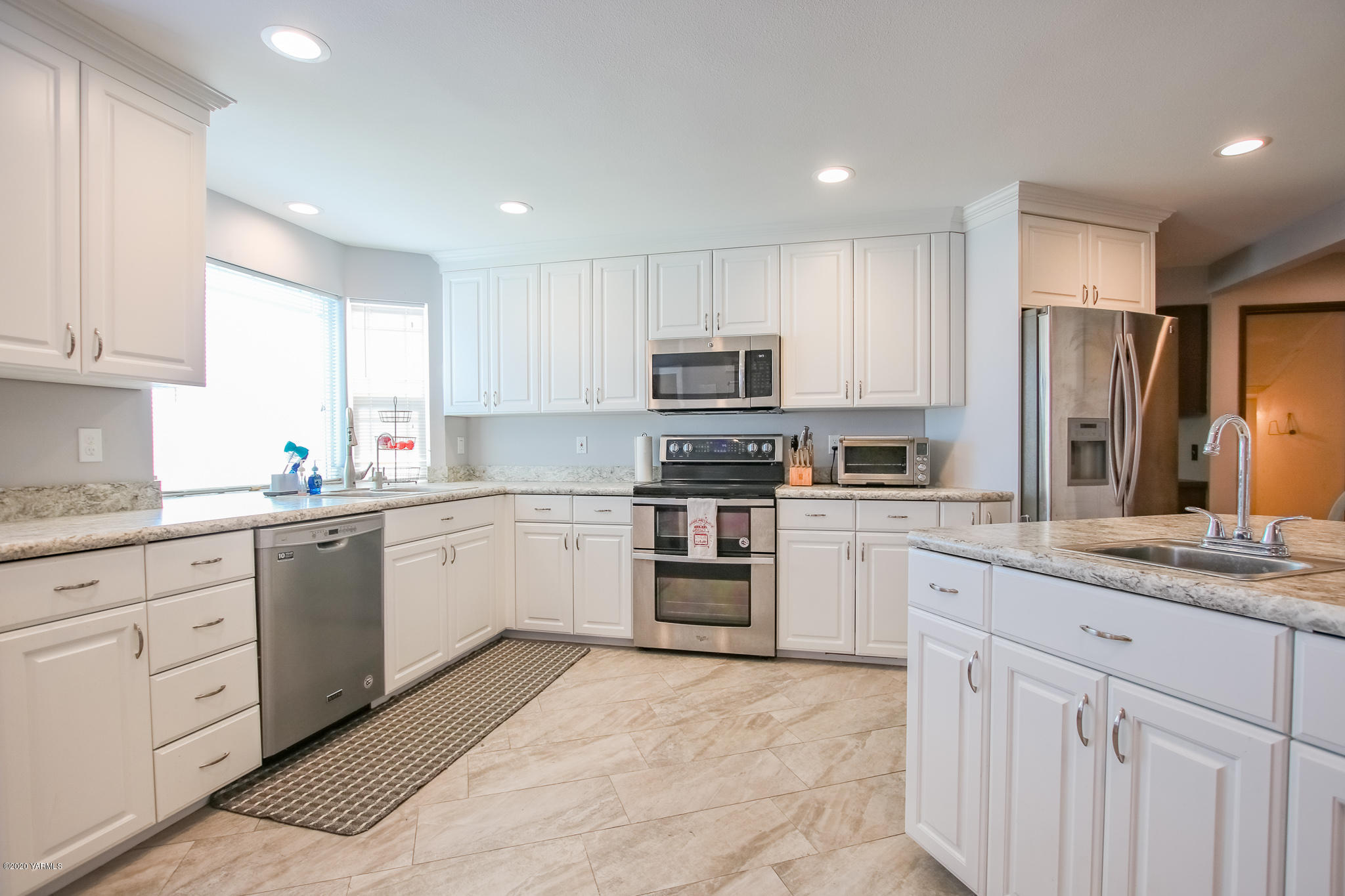 6608 Postma Road Yakima, WA 98901 - Photo 8 of 34 a kitchen with granite countertop white cabinets and stainless steel appliances