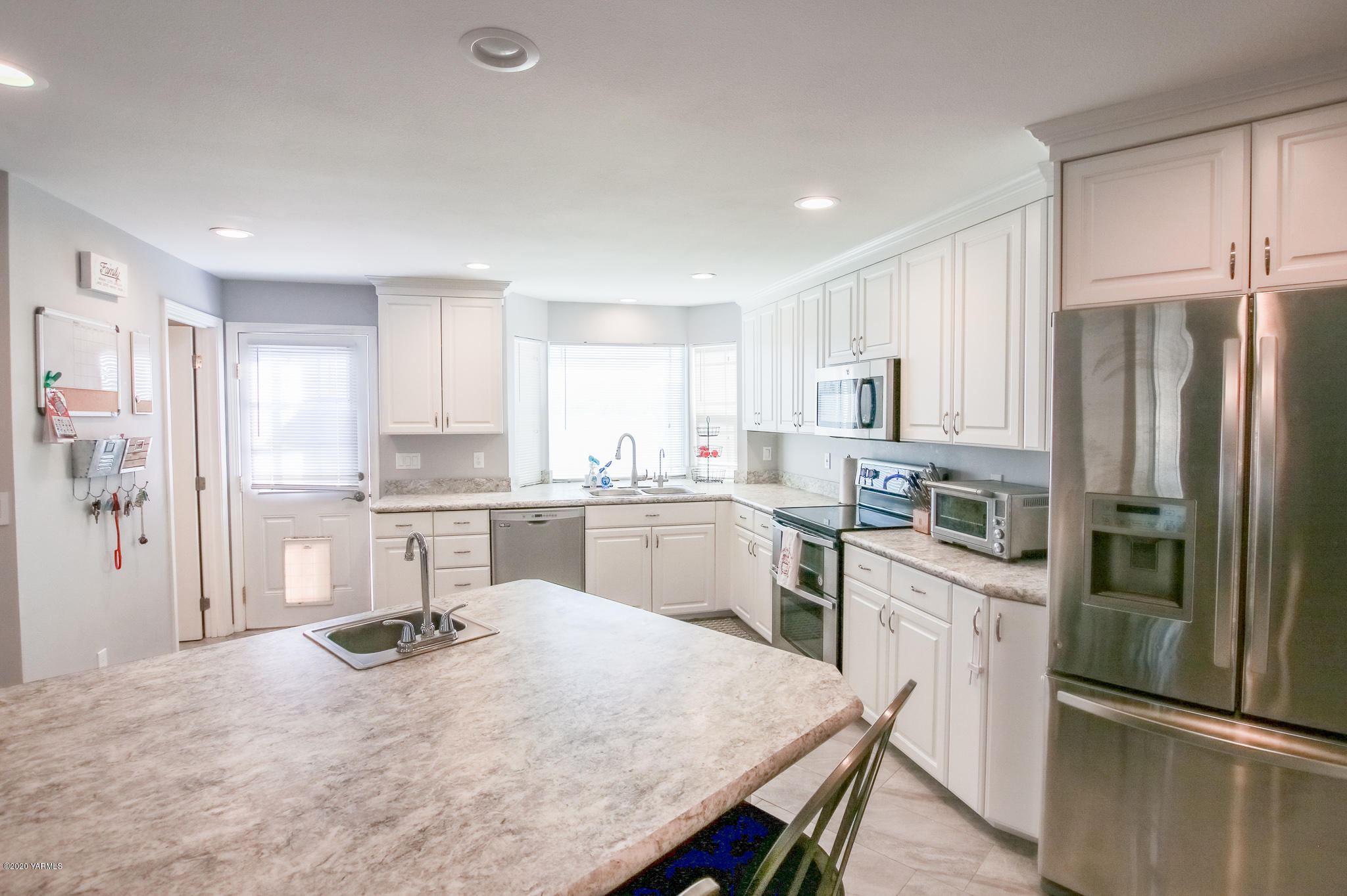 6608 Postma Road Yakima, WA 98901 - Photo 10 of 34 a kitchen with a refrigerator a sink and cabinets