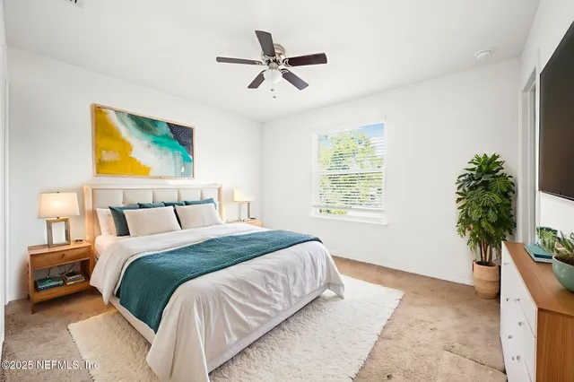 a bedroom with a bed and a potted plant
