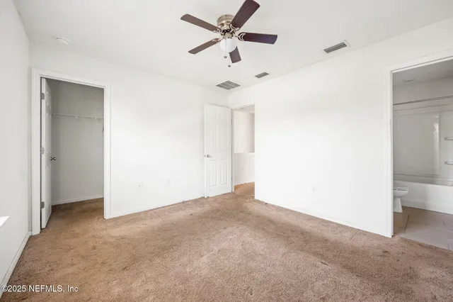 an empty room with a ceiling fan and a window