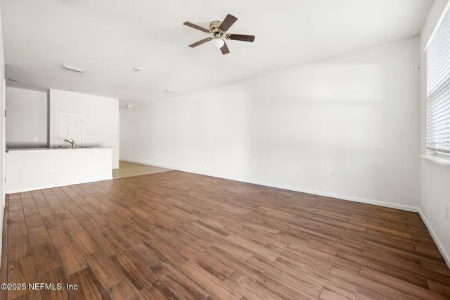 wooden floor in an empty room with a window