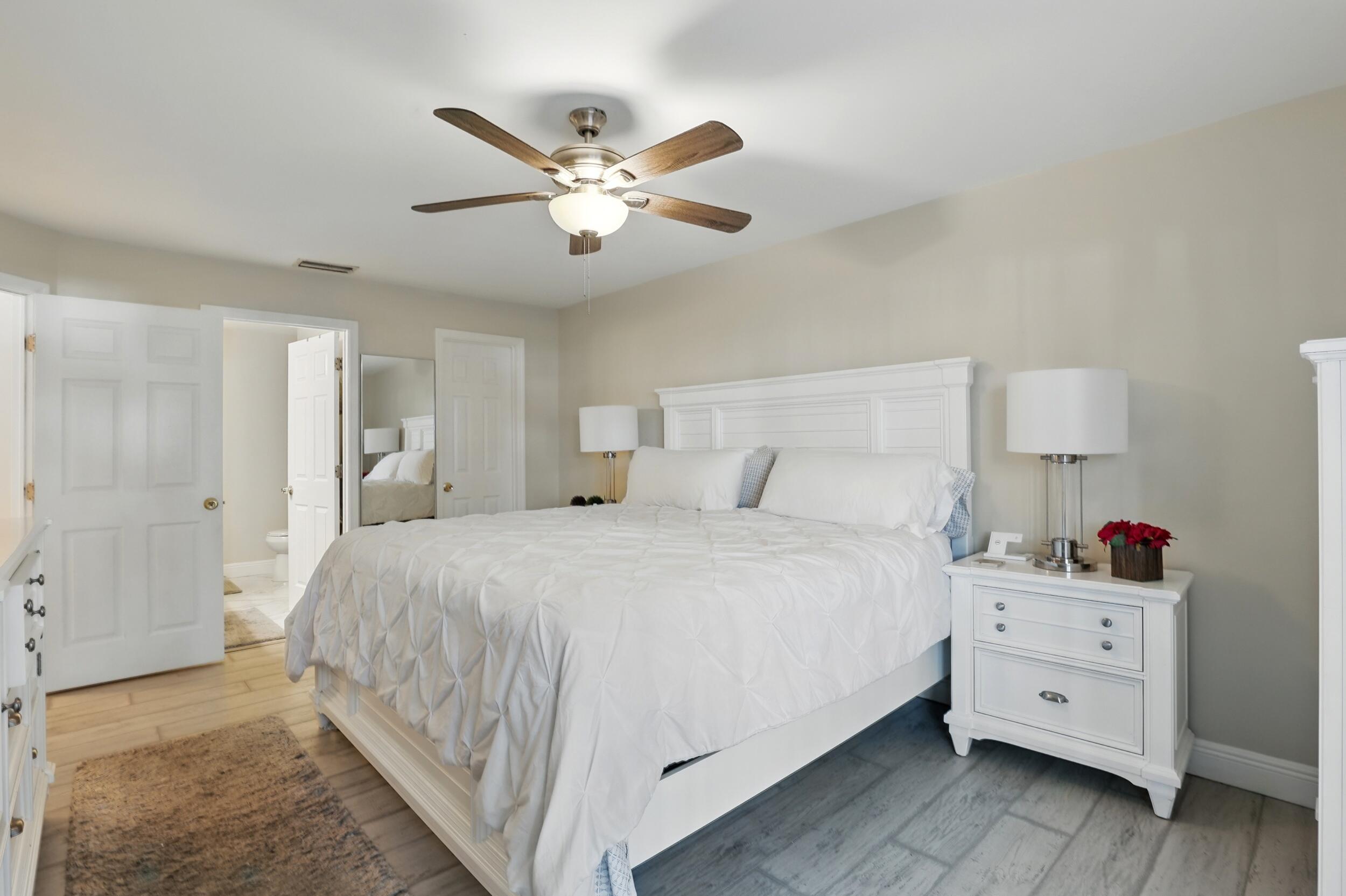 4491 Willow Pond Road, Unit B West Palm Beach, FL 33417 - Photo 19 of 29 a bedroom with a bed and a chandelier