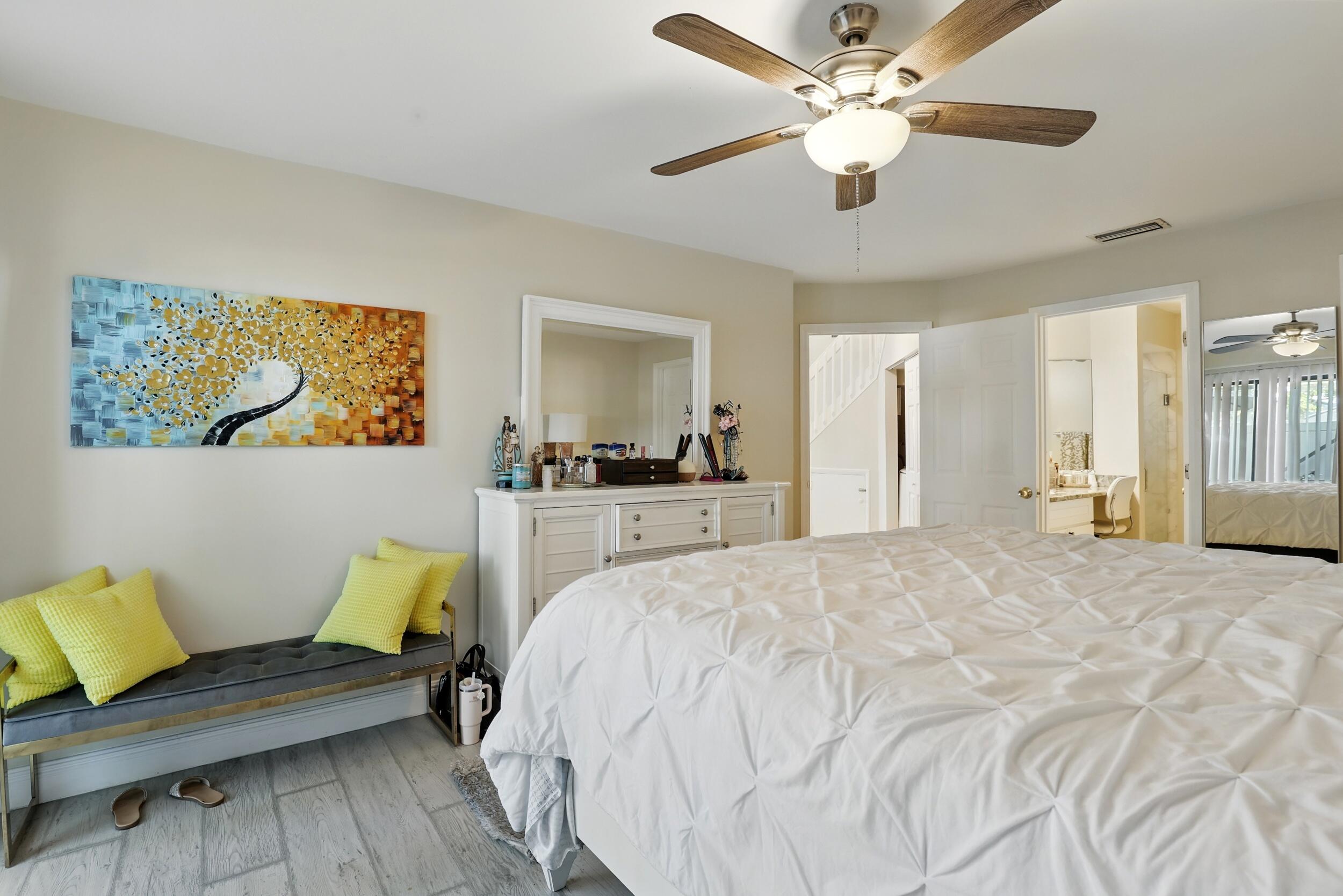 4491 Willow Pond Road, Unit B West Palm Beach, FL 33417 - Photo 20 of 29 a spacious bedroom with a bed and a chandelier