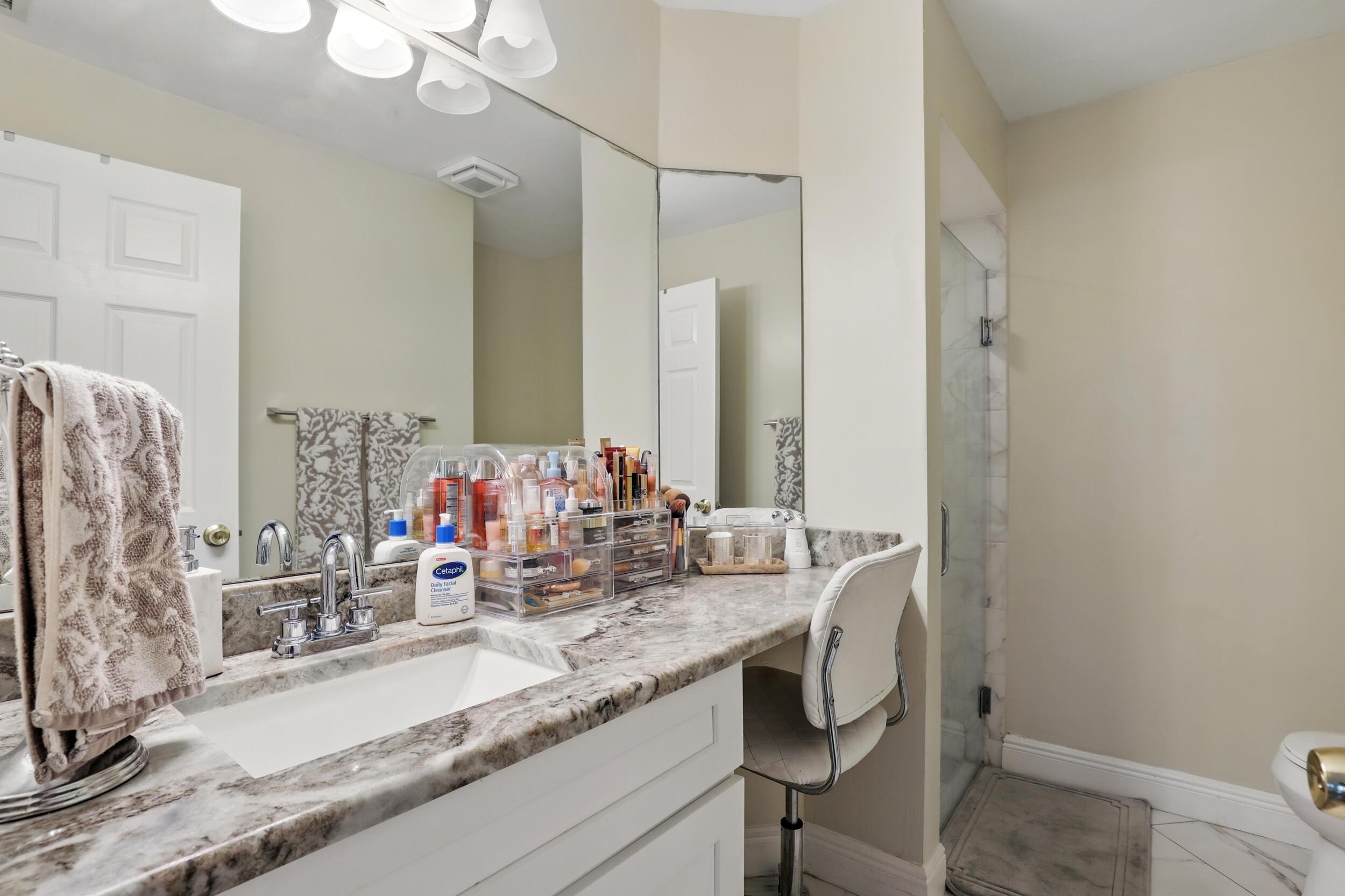 4491 Willow Pond Road, Unit B West Palm Beach, FL 33417 - Photo 21 of 29 a bathroom with a granite countertop sink and a mirror