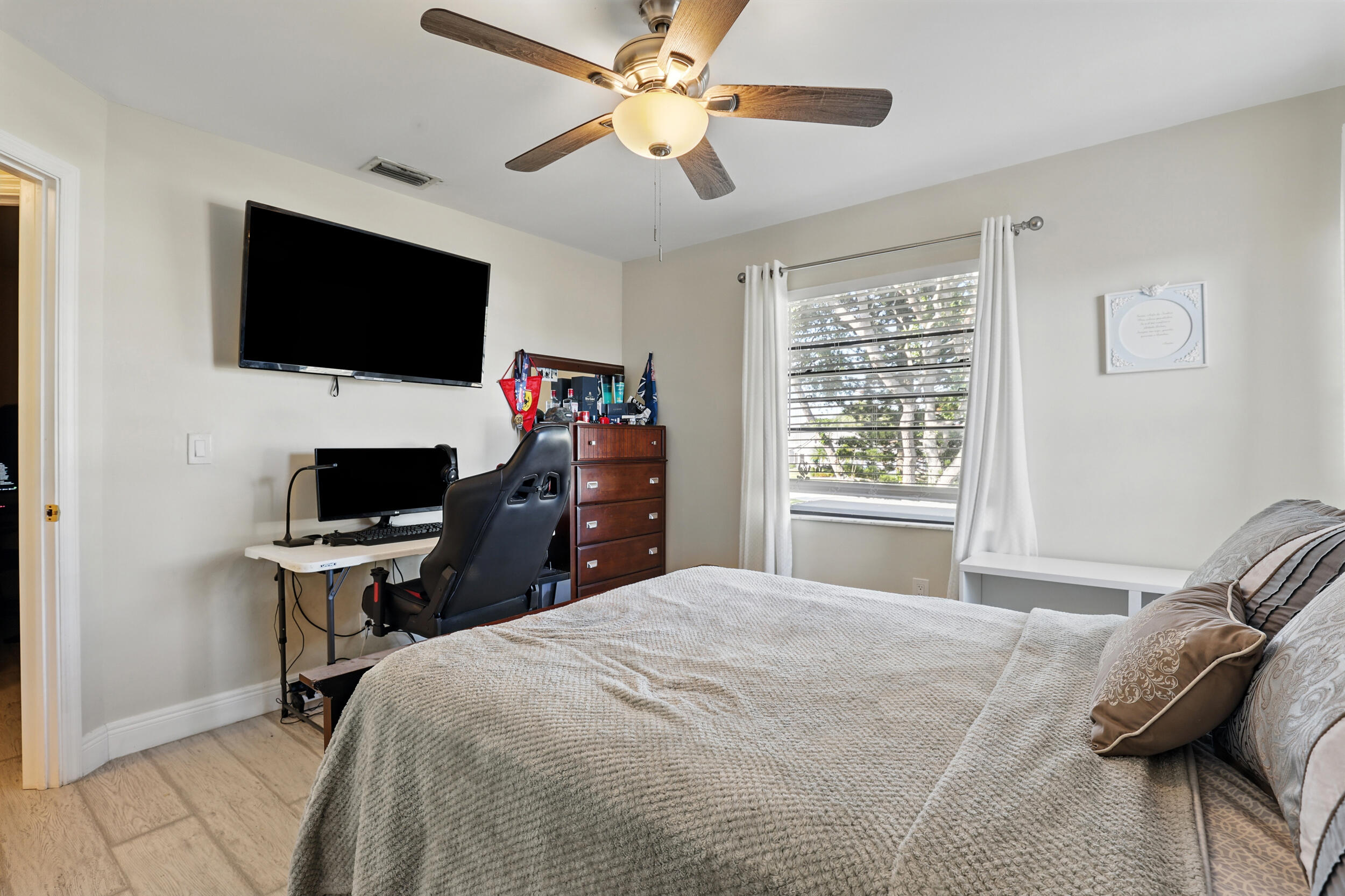 4491 Willow Pond Road, Unit B West Palm Beach, FL 33417 - Photo 24 of 29 a bedroom with a bed tv and a window