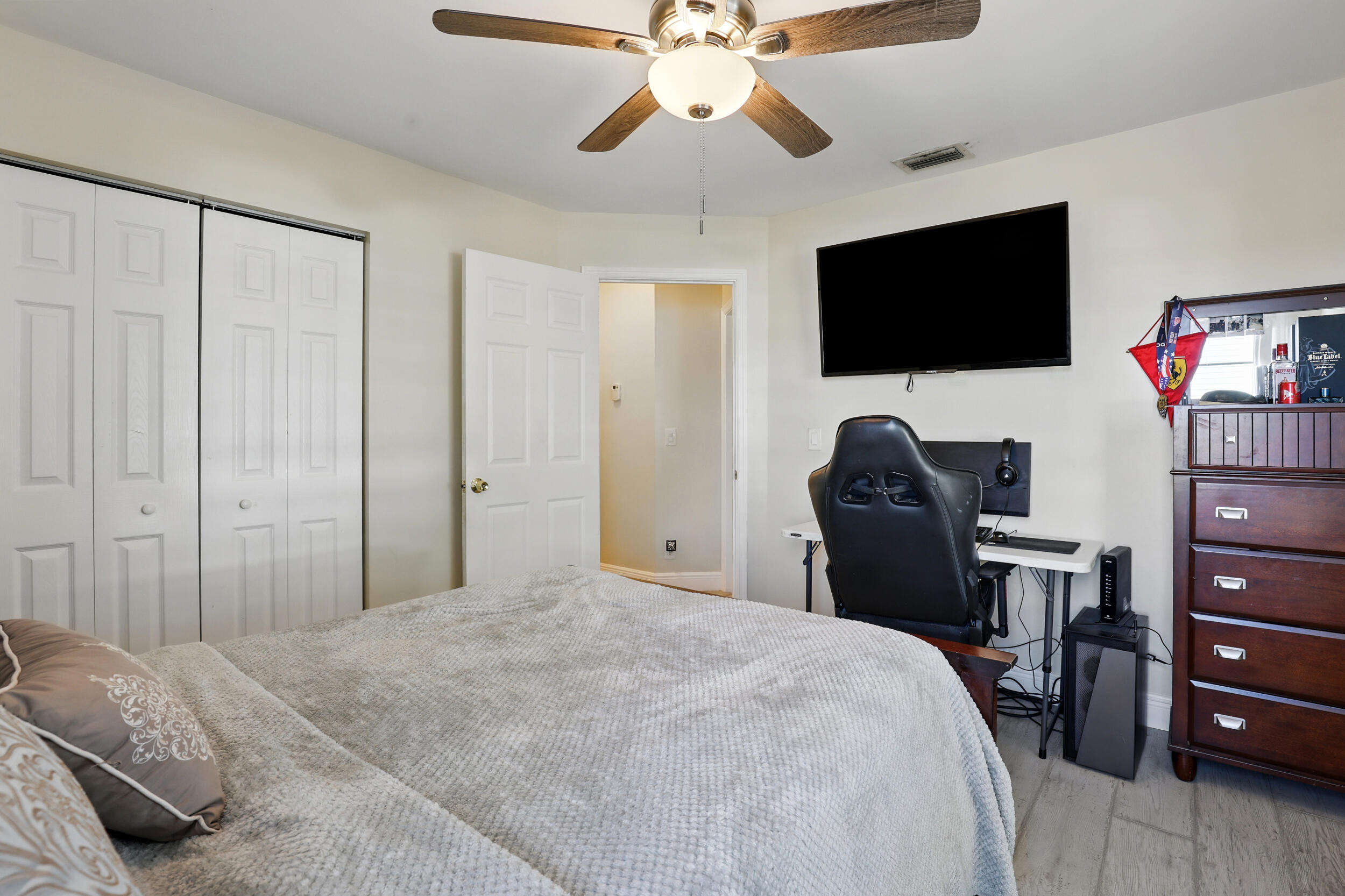 4491 Willow Pond Road, Unit B West Palm Beach, FL 33417 - Photo 25 of 29 a bedroom with a bed and a flat screen tv