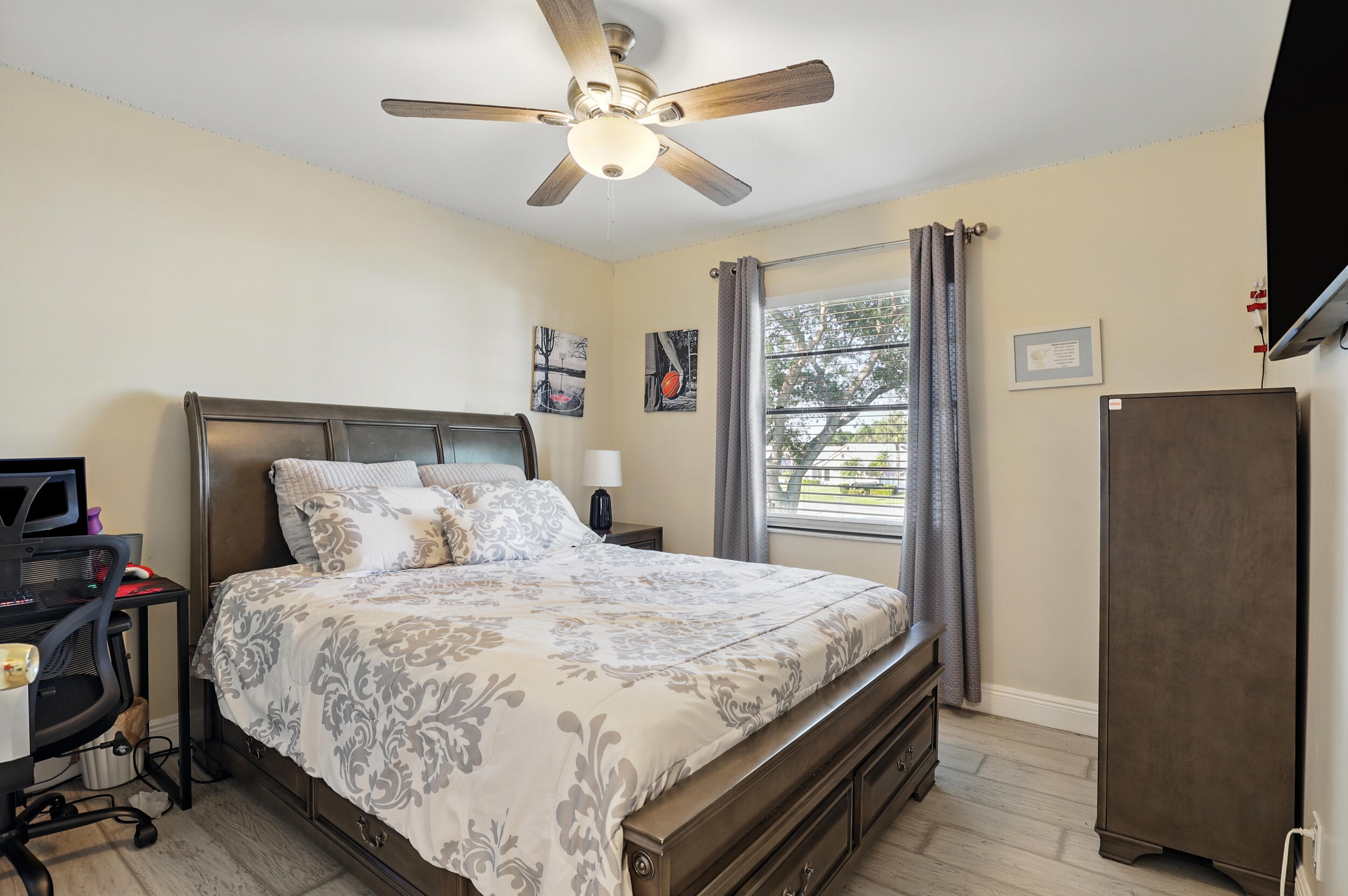 4491 Willow Pond Road, Unit B West Palm Beach, FL 33417 - Photo 26 of 29 a bedroom with a balcony a bed and a flat screen tv