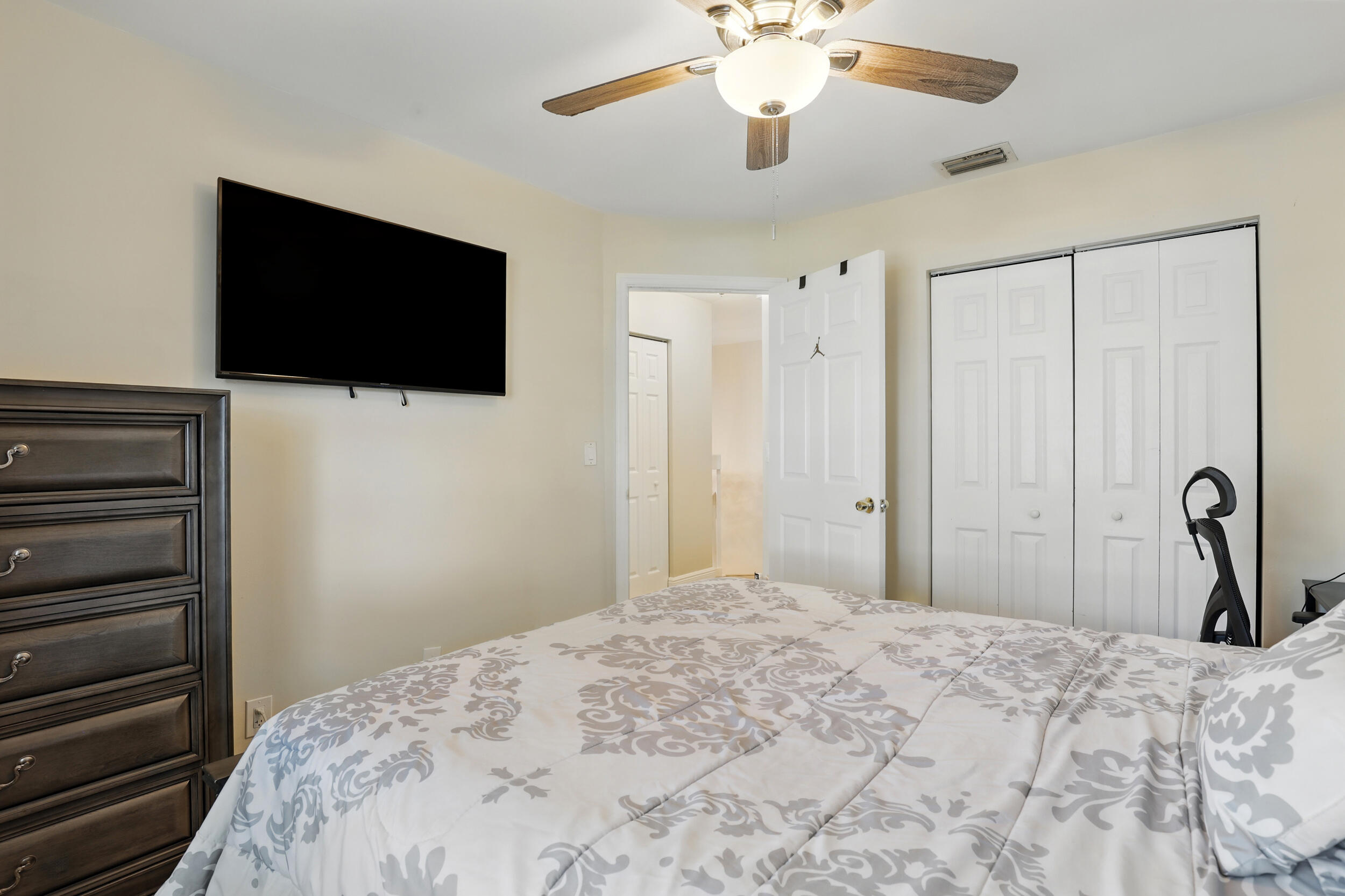 4491 Willow Pond Road, Unit B West Palm Beach, FL 33417 - Photo 27 of 29 a bedroom with a bed and a flat screen tv