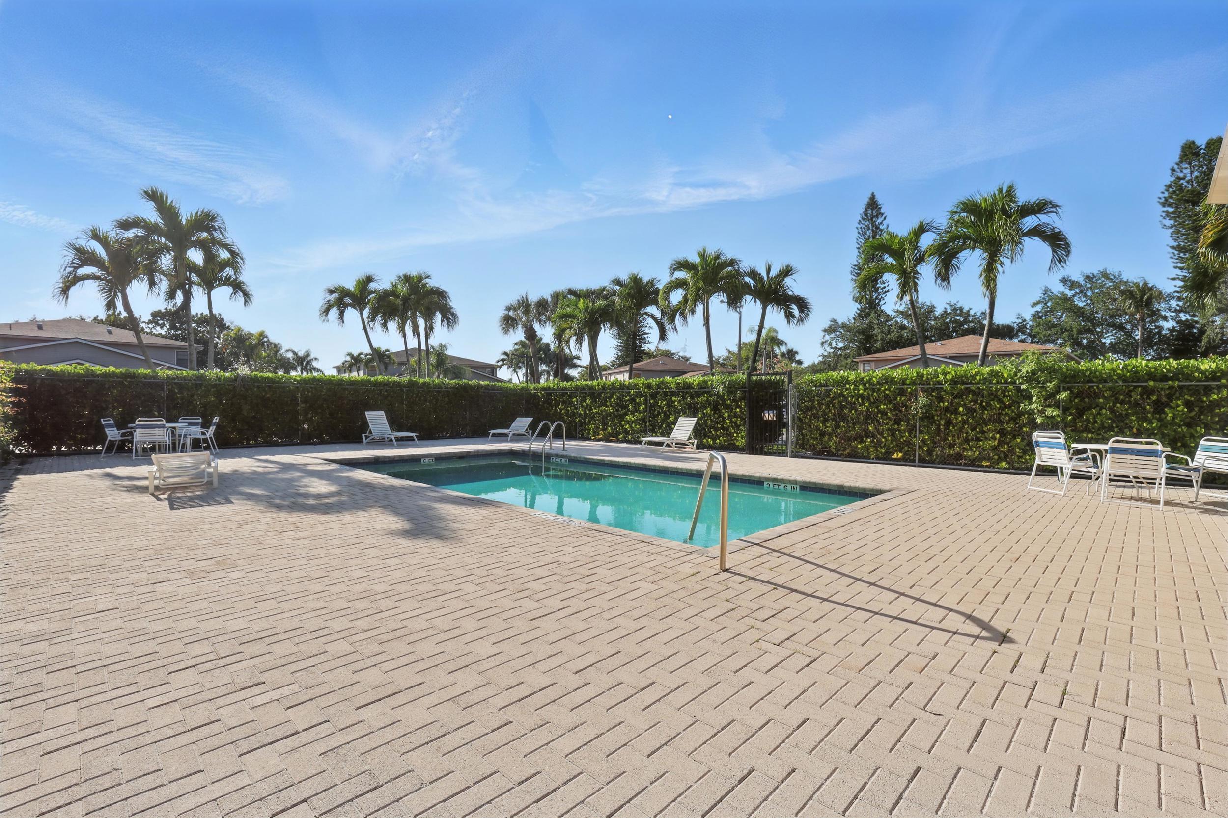 4491 Willow Pond Road, Unit B West Palm Beach, FL 33417 - Photo 5 of 29 a view of a swimming pool with a yard and plants