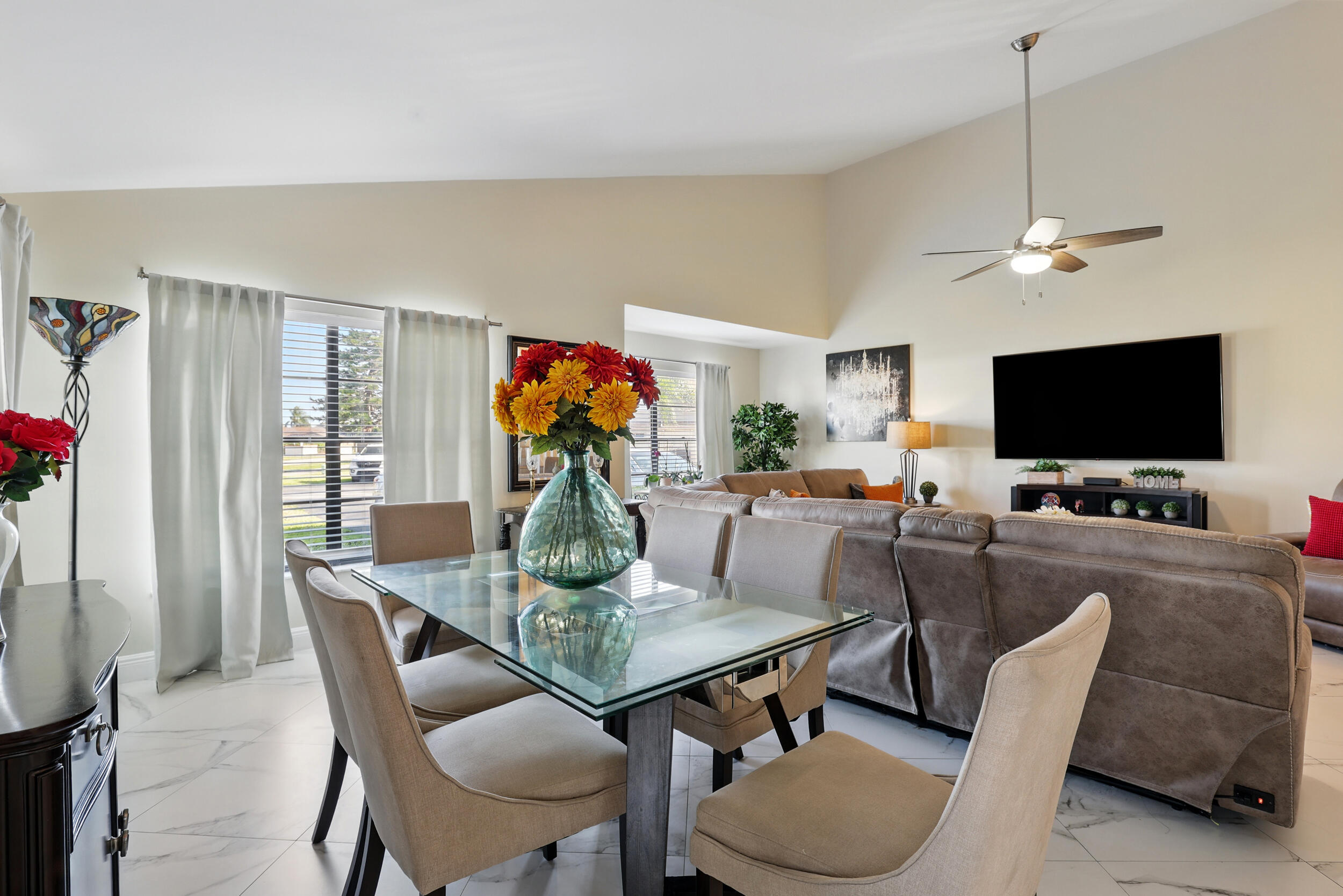 4491 Willow Pond Road, Unit B West Palm Beach, FL 33417 - Photo 10 of 29 a view of a livingroom and dining room with furniture wooden floor a flat screen tv and a chandelier