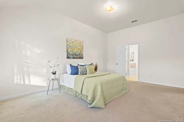 a bedroom with a bed and a painting on the wall