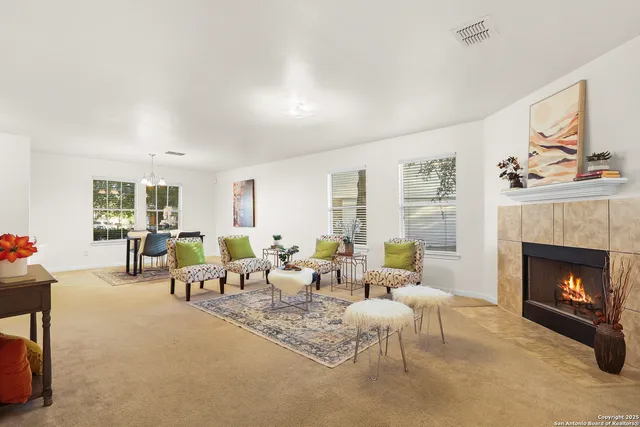 a living room with furniture two window and a fireplace