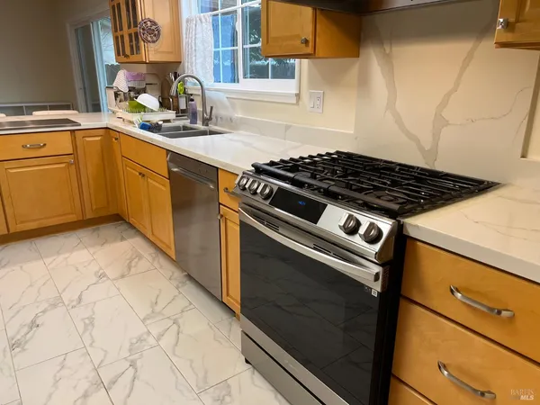 a kitchen with granite countertop cabinets a sink and a stove