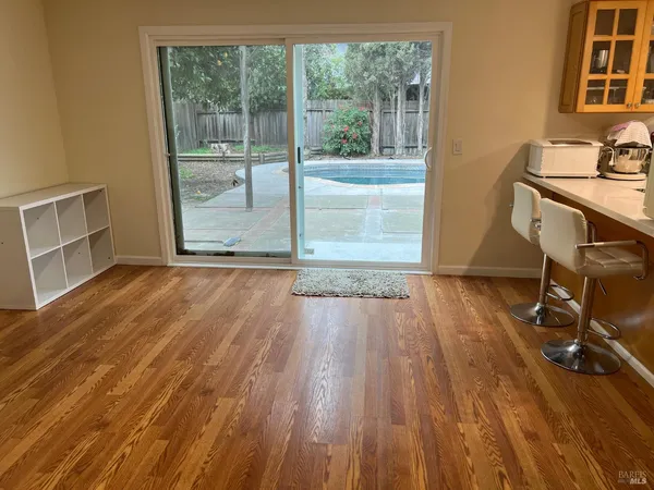 a view of a workspace with wooden floor and a window