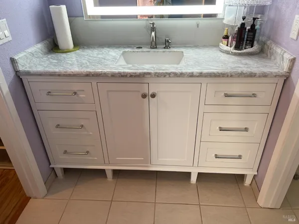 a bathroom with a granite countertop sink and vanity