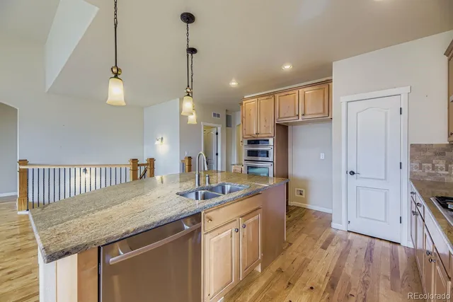 a kitchen with stainless steel appliances granite countertop a sink stove and wooden floor