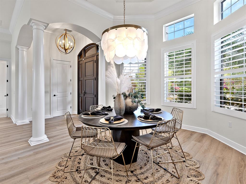 7431 Greystone Street Lakewood Ranch, FL 34202 - Photo 16 of 85 a dining room with furniture a chandelier and wooden floor