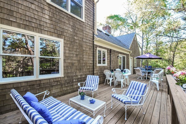 55 Captain Carltons Road Barnstable, MA 02635 - Photo 6 of 24 a view of a patio with a dining table and chairs with wooden floor and fence